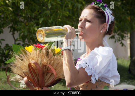 Eine junge Frau in Volkstracht, trinkt den weißmährischen Wein aus der Flasche, Feier der guten Ernte, Jevisovice, Tschechien Stockfoto