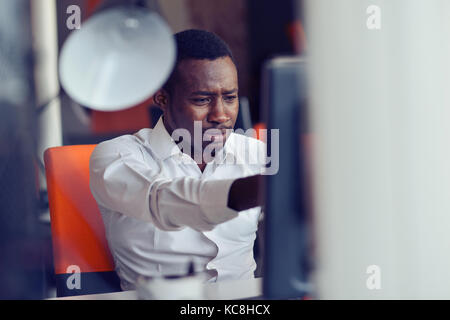 Enttäuscht afrikanischen Geschäftsmann ist betäubt und durch einen Fehler in offiziellen Dokumenten verwirrt. Stockfoto