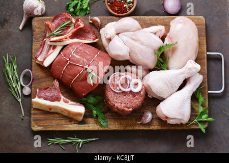 Rohes Fleisch Sortiment - Rind, Lamm, Huhn auf einem Holzbrett Stockfoto