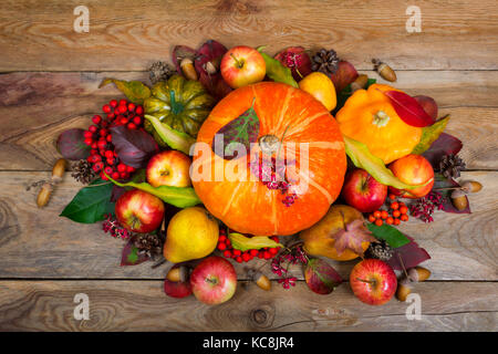 Thanksgiving Anordnung mit Kürbisse, Äpfel, Birnen, Vogelbeeren, bunte Blätter und Eicheln auf der rustikalen Holzmöbeln Hintergrund Stockfoto