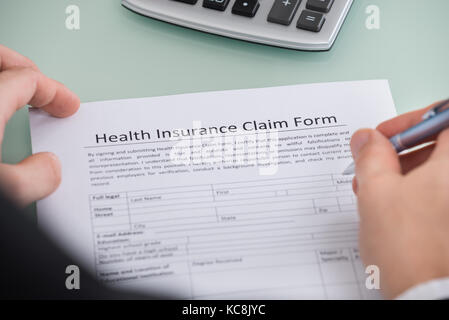 Nahaufnahme der Person Befüllen Krankenversicherung Antragsformular. Stockfoto