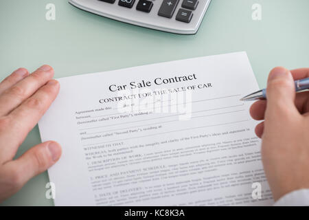 Nahaufnahme einer Person ausfüllen Auto Verkauf Vertrag Formular Stockfoto