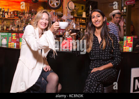 Tausendjährige und eine midlifer swapping Trinkgewohnheiten in einer lokalen Bar in London, Großbritannien Stockfoto
