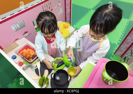 Asiatische chinesische Mädchen Rollenspiel in der Küche im Indoor Spielplatz Stockfoto