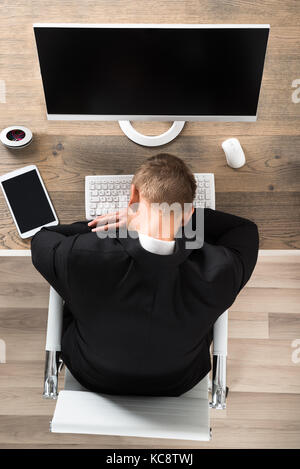 Junge Unternehmer schlafen auf dem Schreibtisch im Büro Stockfoto