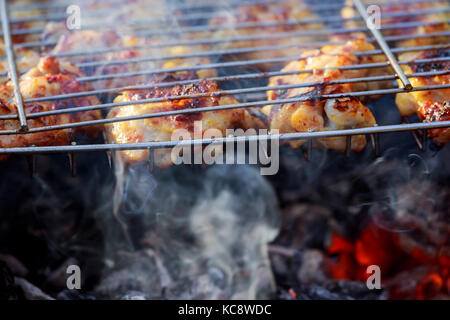 Close up Gegrilltes Hühnerfleisch wird am Feuer und Rauch Herd Stockfoto