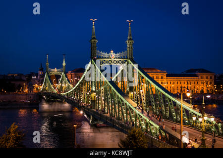 Budapest, die Hauptstadt Ungarns, Nacht Panorama. Die beleuchtete Brücke, auf der Donau und der wirtschaftsuniversität auf der Pester Seite. Stockfoto