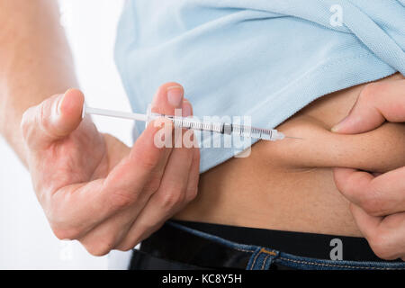 Nahaufnahme der Diabetischen jungen Mann Injektion Magen Stockfoto