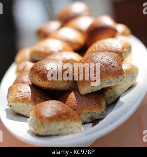 Frisch gebackenen Weizen Brötchen mit Mohn auf dem weißen Teller Stockfoto