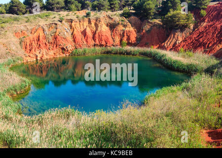Der See in roten Böden ist eine alte Bauxit Steinbruch Höhle in Apulien, Salento, Otranto, Italien. Das Graben wurde mit natürlichem Wasser gefüllt. Stockfoto
