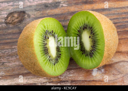 Zwei kiwi Stücke sitzen auf dem Schneidebrett o halbiert Stockfoto