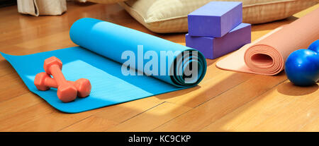 Pilates Equipment. trainingsmatten und Hanteln auf Holzboden Stockfoto