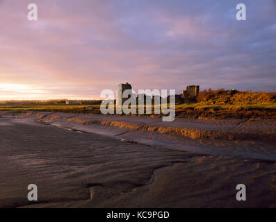 Flint Castle, Fintshire, Wales. Blick nach Süden am ruiniert Nordwand und Türmen. Von Wattenmeer Dee Estuary bei Sonnenaufgang gesehen. Stockfoto