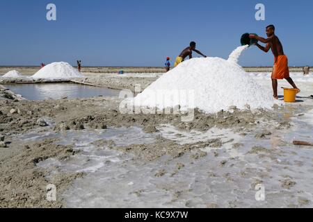 BELO, MADAGASKAR, 24. November 2015 : Menschen arbeiten in Salzverdunstungsbecken in der Nähe von Belo-sur-Mer, um Salze aus Meerwasser zu extrahieren. Stockfoto