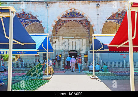 Antalya, Türkei - 13. Mai 2017: Die Muslime, die Murat Pascha Moschee gehen und für den Freitag Gebet vorbereiten, die Straße ist voller Teppiche und großen Su Stockfoto