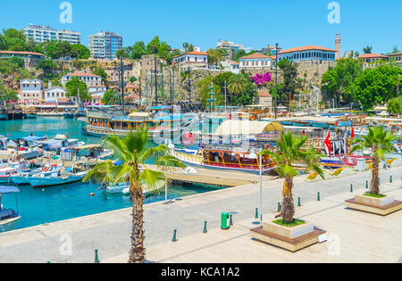Die malerische Strandpromenade mit Palmen in den alten Hafen von Kaleici, günstig Yachten und Schiffe und von hohen Klippen und alten Festung Mauern umgeben, ein Stockfoto