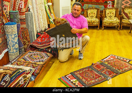 Antalya, Türkei - Mai 12, 2017: Der Anbieter von Teppich Store demonstriert die antiken handgeknüpften Kamel Satteltaschen, alte Basar in Antalya, die am 12. Mai. Stockfoto