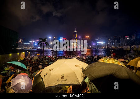 Tsim sha Tsui, Kowloon, Hong Kong - 2 Oktober: gedrängten Menschen warten auf nationaler Tag Feuerwerk im Regen Anzeige am Ufer des Victoria Harbour von Ho Stockfoto