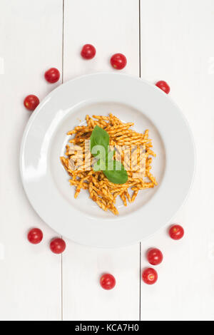 Trofie, Pasta mit Tomatenmark, Basilikum und Tomaten auf weißem Hintergrund Stockfoto