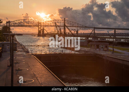 Sault Ste Marie, Michigan - Sonnenuntergang über der Soo Locks und der internationalen Autobahn und Eisenbahn Brücken nach Kanada. die Schleusen zwischen Versand Stockfoto