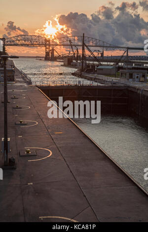 Sault Ste Marie, Michigan - Sonnenuntergang über der Soo Locks und der internationalen Autobahn und Eisenbahn Brücken nach Kanada. die Schleusen zwischen Versand Stockfoto