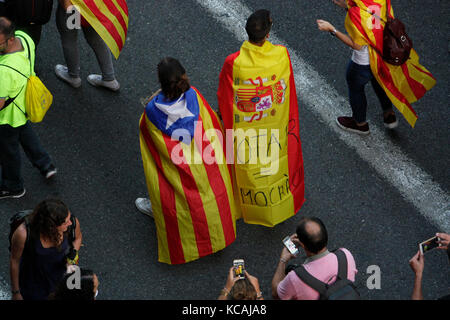 Barcelona, Spanien. 3. Oktober 2017. Ein Paar, das gegensätzliche Flaggen trägt, eine aus Katalonien und die andere eine spanische Flagge. Bilder vom Plaza Universidad, Barcelona, während eines Generalstreiks, der heute (3.10.2017) im gesamten spanischen Staat Katalonien stattfand, nach dem inoffiziellen Referendum, das zuvor am Sonntag, dem 1.10.2017, abgehalten wurde. Die spanische Regierung hat das Referendum als illegal und verfassungswidrig eingestuft. Foto: RICH BOWEN Credit: rich bowen/Alamy Live News Stockfoto