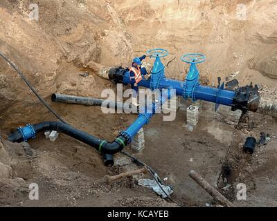 Technischer Experte u-Schieber auf 500 mm Wasser trinken Rohre verbunden mit neuen Schwarz Multi Achsen Exzenter Verschluss in alte Pipeline System. Stockfoto