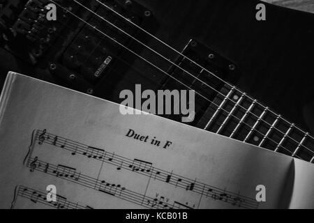 Eine elektrische Gitarre Instrument und ein Stück Musik- und Notes book schwarz und weiß Stockfoto