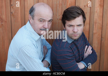 Vater und Sohn stritten. Sie schauen mit verärgerten Emotion an Kamera, Arme gekreuzt Stockfoto