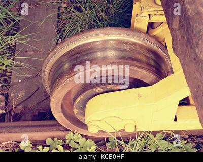 Cargo wagon wheel Aufenthalt auf rostigen Eisenbahn. alten Eisenbahnwaggon warten im Depot. frische grüne Gras um Schiene Stangen Stockfoto