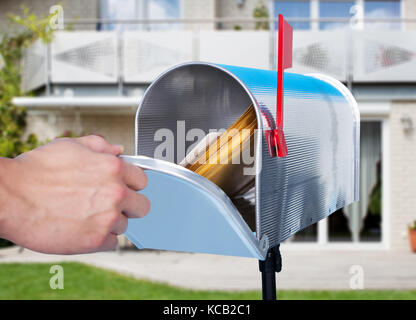 Nahaufnahme einer Person hand Überprüfung des Postfachs außerhalb des Hauses Stockfoto