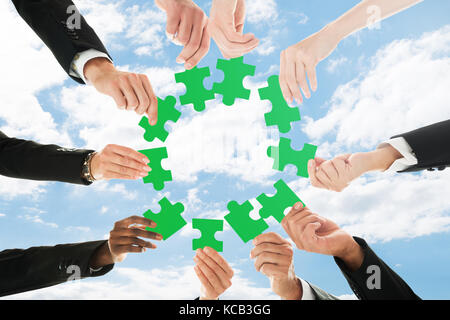 Low Angle View eines Geschäftsleute halten Puzzle gegen Sky Stockfoto