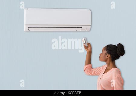 Ein Afrikanischer junge Frau mit Klimaanlage zu Hause Stockfoto
