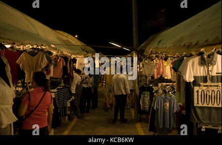 Ein Korridor zwischen Ständen Kleidung an der Phnom Penh Nachtmarkt in Kambodscha, in Südostasien. Viele t-shirts auf dem Display, günstige Preise Stockfoto