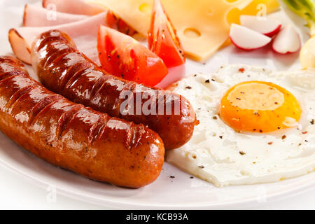 Frühstück - Spiegeleier, Würstchen, Käse, Schinken und Gemüse Stockfoto