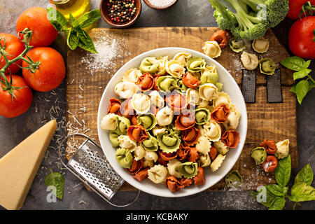 Rot, weiß und grün Tortellini mit Gemüse und Käse Stockfoto