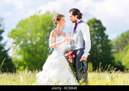 Brautpaar feiern Hochzeit mit Champagner Stockfoto