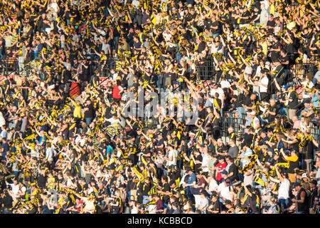 Richmond Football Club Fans stehen und Anfeuern ihrer Mannschaft im Jahr 2017 vorläufigen Finale bei den MCG, Melbourne Cricket Ground, Victoria, Australien. Stockfoto