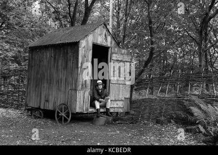 Frau entspannend mit Buch auf Waldgarten Schuppen auf Rädern Großbritannien abgeschiedenes Abgeschiedenheit in der Abgeschiedenheit, ein Refugium auf dem Land Stockfoto