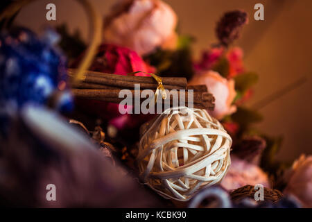 Gemahlener Zimt, Zimtstangen, mit einem Tablett mit einem Bogen auf einem floral background im rustikalen Stil verbunden. Selektive konzentrieren. Essen Konzept. Jahrgang zu Stockfoto