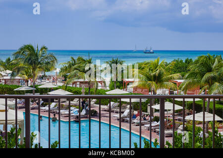 Aruba - EIN Blick auf die Südkaribische See von Palm Beach auf der Insel Aruba. Vordergrund: Coconut Palms und ein Teil des Ritz-Carlton Hotels Stockfoto