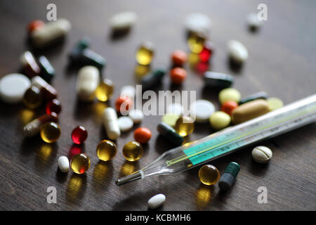 Medikamente und Tabletten auf einer hölzernen Textur Tabelle Stockfoto