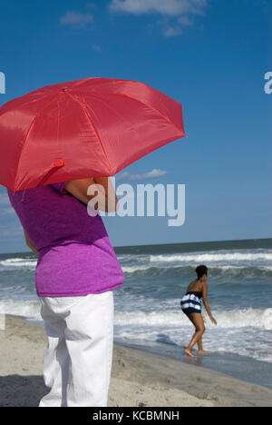 Frau mit roten Regenschirm während der Anzeige der Ozean Myrtle Beach, SC, USA. Stockfoto