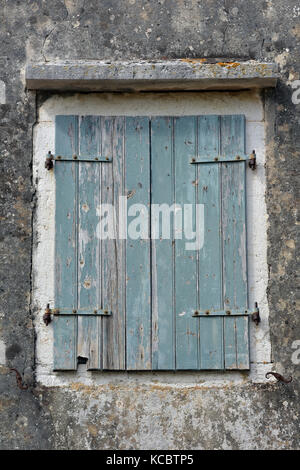 Ein paar grüne Fensterläden in einem alten Bauernhaus im Shabby Chic Stil und mit Peeling abblätternden grünen Lackierung. Distressed Wetter abgenutzt aussehen. Stockfoto