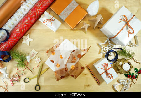 Verpackung Weihnachtsgeschenke Overhead mit Rollen Geschenkpapier. Stockfoto