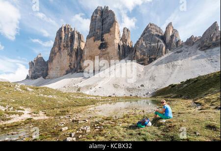 Wanderer macht eine Pause,Gesichter der Drei Zinnen von Lavaredo, See in der Nähe von Col forcellina, Sextner Dolomiten Stockfoto