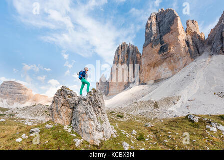 Wanderer steht auf Felsen, nordwände der Drei Zinnen von Lavaredo, Sextner Dolomiten, Südtirol, Trentino - Südtirol Stockfoto