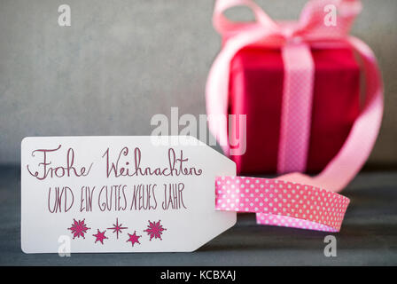 Rosa Geschenk, Kalligraphie, frohe Weihnachten bedeutet frohe Weihnachten Stockfoto