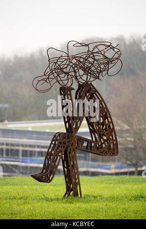 Outdoor Metall Skulptur von stilisierten Mann sitzt im Feld Stockfoto
