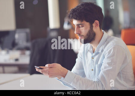 Young Business Mann arbeitet auf dem Desktop Computer an seinem Schreibtisch in der modernen hellen startup Office Interior Stockfoto